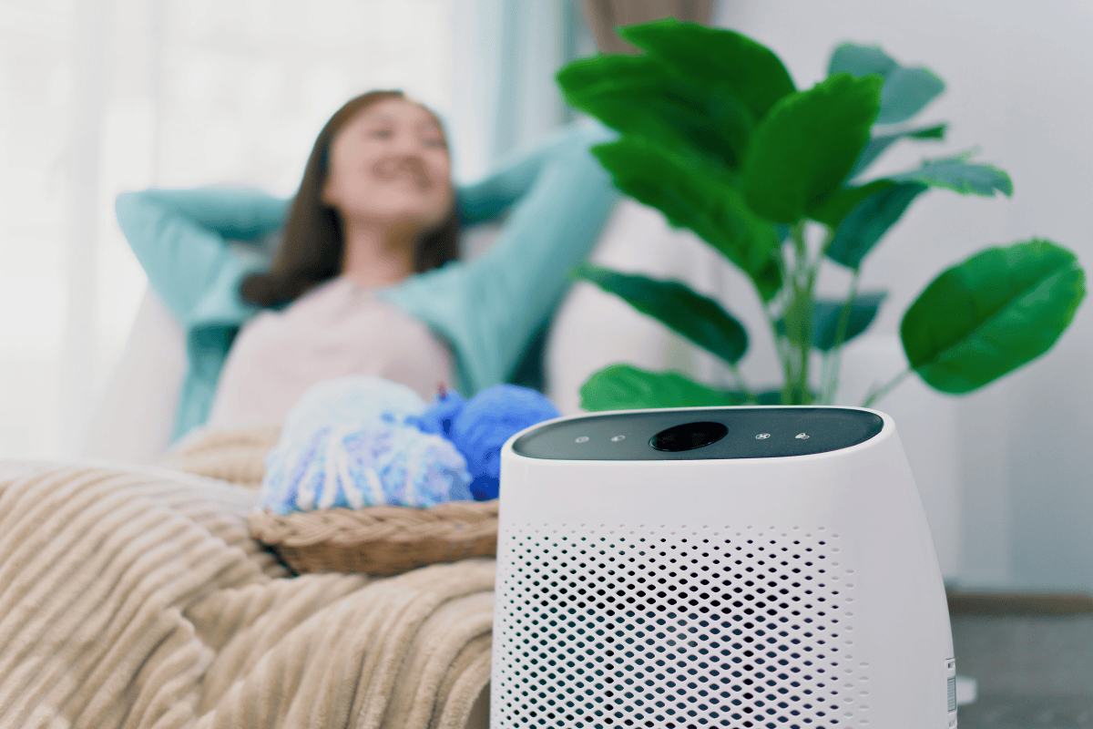 woman relaxing on couch behind air purifier
