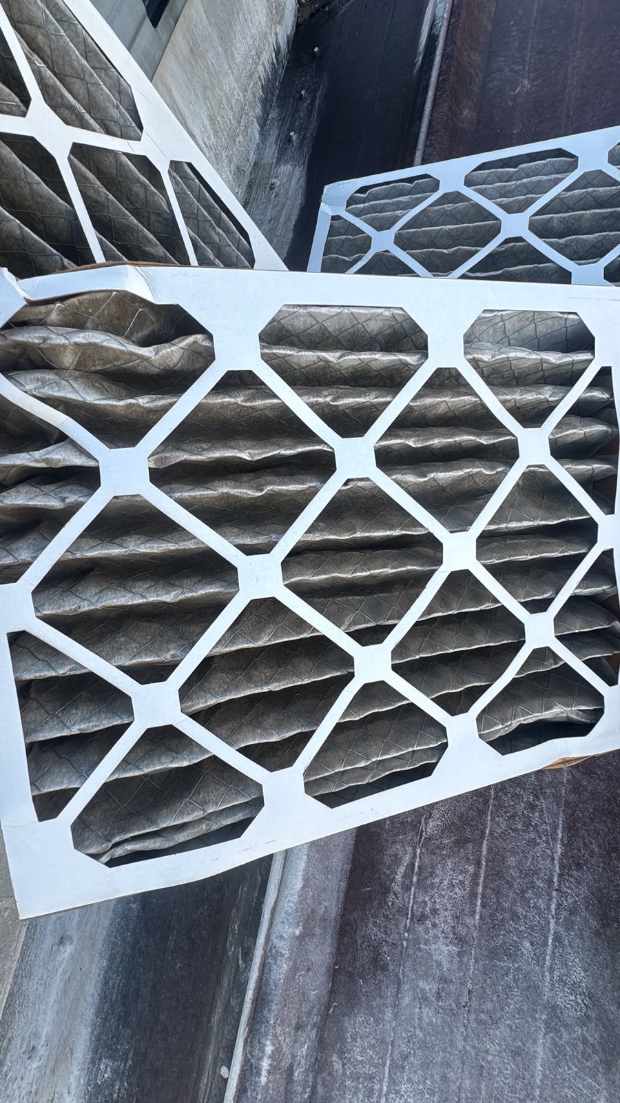 Two dirty pleated air filters pulled from a Georgia home's HVAC system, gray with dust from too long in service