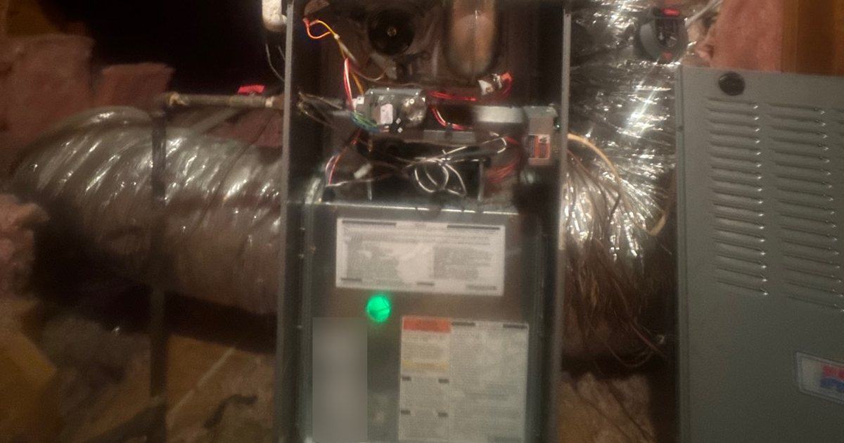 Furnace not heating: an attic gas furnace with its panel off and the green diagnostic light showing on the control board